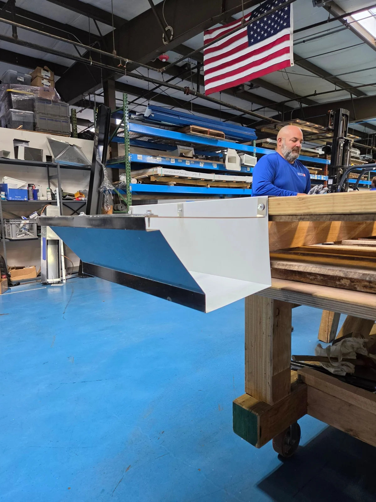 Chaffee metal shop team member with a fabricated component at the workbench